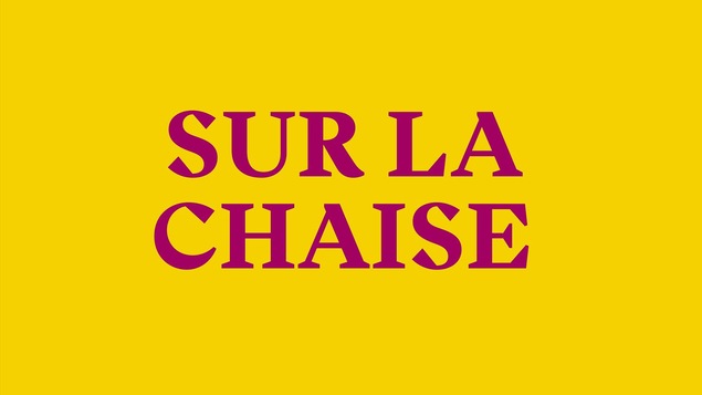 Sur la chaise, inscription fuchsia sur fond jaune