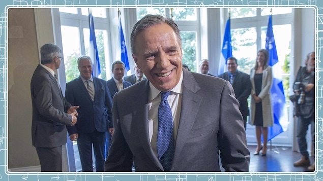 François Legault en gros plan devant quelques députés élus.