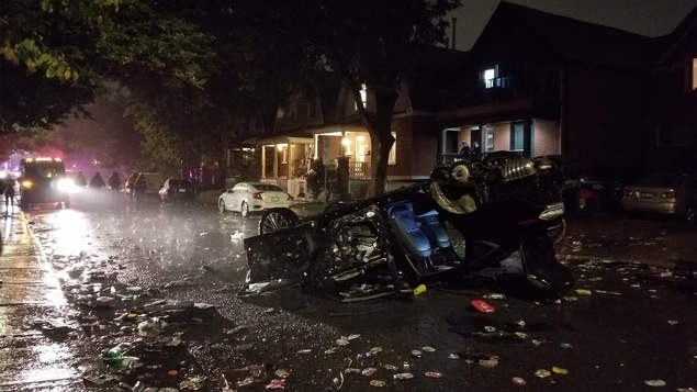 Une voiture renversée entourée de débris.