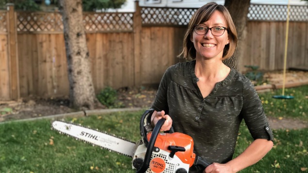 Karen Watson dans sa cour à Moose Jaw une tronçonneuse à la main.