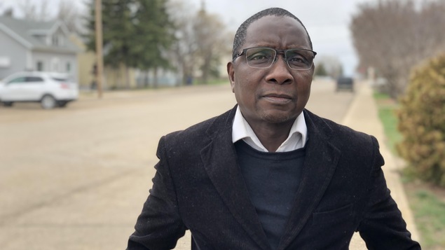 Ousmane Ilbo Mahamane debout dans une rue de Gravelbourg.
