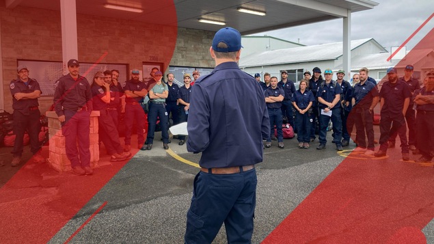 Un groupe de pompiers ressemblés dans le stationnement de l'aéroport.
