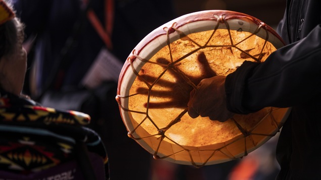 Une main sur un tambour lors d'une cérémonie pour honorer les survivants des pensionnats pour Autochtones. 