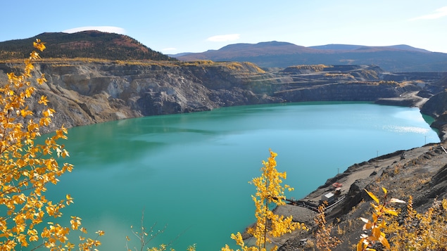 Un lac est au creux de la mine à ciel ouvert.
