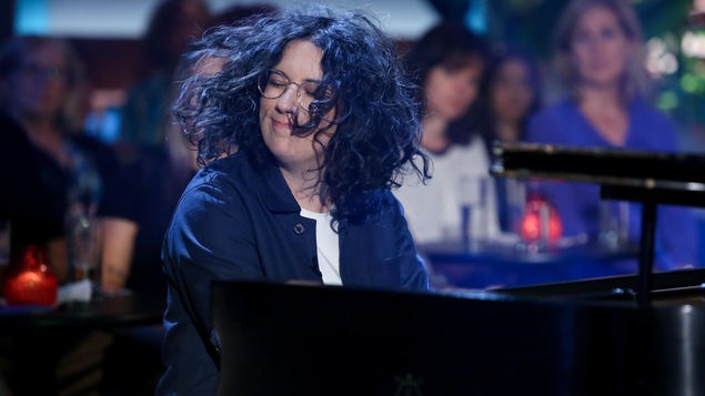 Elle joue du piano, ses cheveux frisés en mouvement autour de son visage. Elle joue du piano, ses cheveux frisés en mouvement autour de son visage.