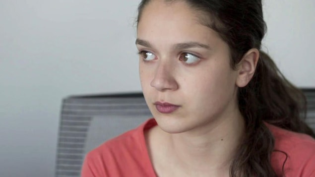 Une jeune fille aux yeux et aux cheveux bruns. Elle fixe attentivement quelqu'un ou quelque chose. Une jeune fille aux yeux et aux cheveux bruns. Elle fixe attentivement quelqu'un ou quelque chose.