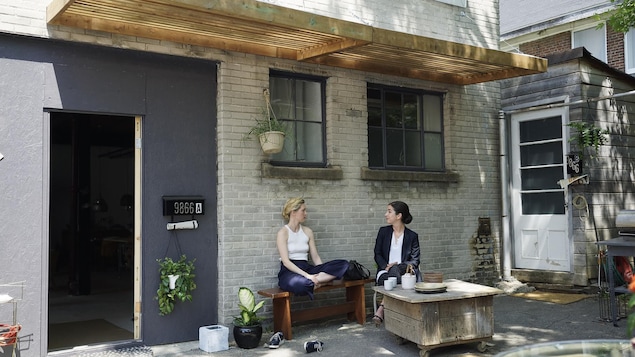 Les deux personnages de Trop assise devant un appartement.