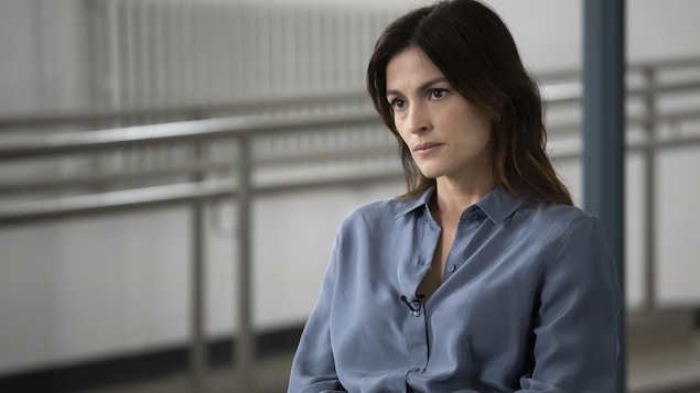 Attentive, Laurence Malo (Madeleine Péloquin) est assise sur un chaise.