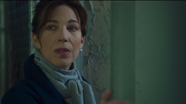 Dans un stationnement sous-terrain, Anne Beaulieu s'arrête et regarde par dessus son épaule. Dans un stationnement sous-terrain, Anne Beaulieu s'arrête et regarde par dessus son épaule.