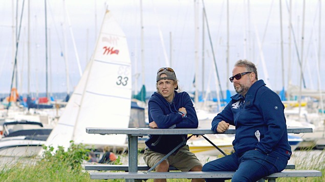Ils sont assis à une table de pique-nique, aux abords d'une marina