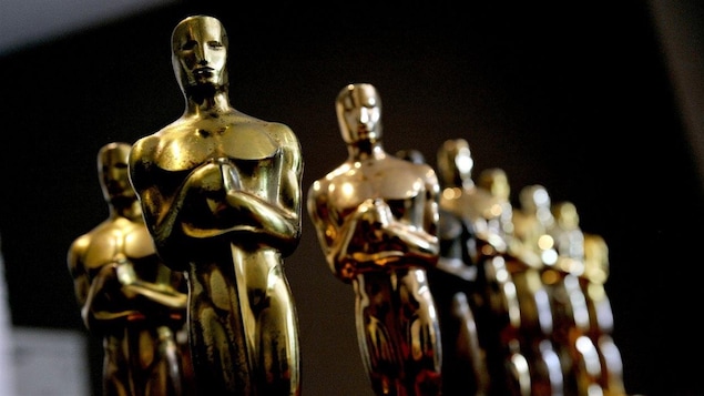 Gros plan sur une série de statuettes dorées.