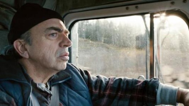 Un homme au volant de son camion. Un homme au volant de son camion.