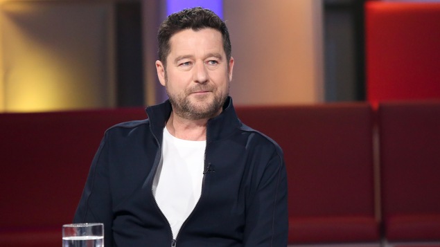 Dany Turcotte porte un t-shirt blanc et un blouson bleu. Dany Turcotte porte un t-shirt blanc et un blouson bleu.