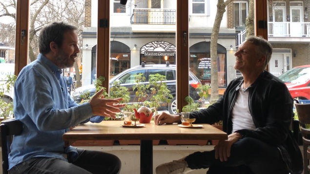 Ils sont assis à la table d'un café, devant une grande fenêtre. Ils sont assis à la table d'un café, devant une grande fenêtre.