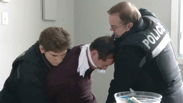 Stéphane tient Éric Crevier pendant que Bruno lui met un revolver sur la tempe. Stéphane tient Éric Crevier pendant que Bruno lui met un revolver sur la tempe.