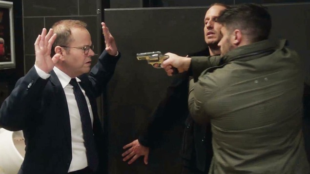 Bruno a les mains dans les airs, car Jonathan Chabot braque un fusil sur lui, pendant qu'il maintient Hugo Lachapelle contre le mur. Bruno a les mains dans les airs, car Jonathan Chabot braque un fusil sur lui, pendant qu'il maintient Hugo Lachapelle contre le mur.