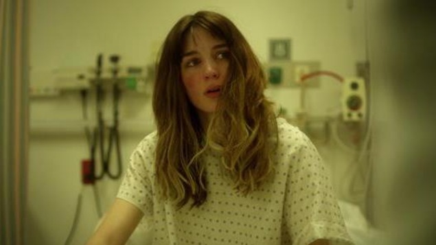 Une femme (Rooney Mara) sur un lit d'hôpital, en jaquette. Une femme (Rooney Mara) sur un lit d'hôpital, en jaquette.