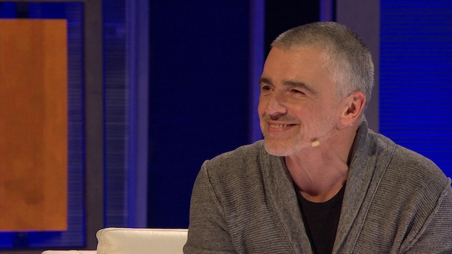 Patrice Godin sourit en regardant une prestation. Patrice Godin sourit en regardant une prestation.