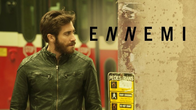 L'affiche du film montrant un homme en blouson de cuir (Jake Gyllenhaal) devant un bus, sous le titre Ennemi. L'affiche du film montrant un homme en blouson de cuir (Jake Gyllenhaal) devant un bus, sous le titre Ennemi.