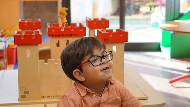 Un petit garçon à lunettes devant un château fort Un petit garçon à lunettes devant un château fort
