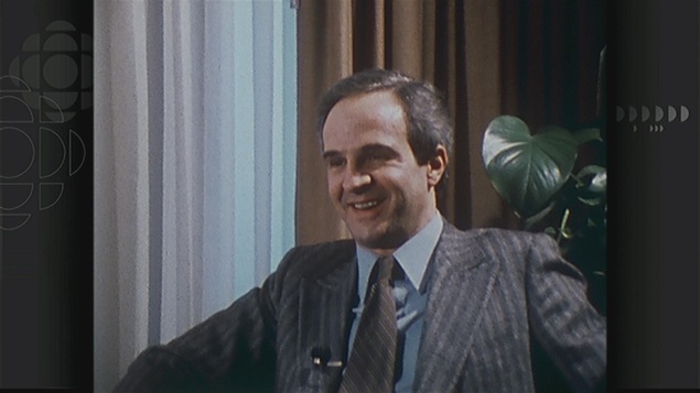 Un homme (François Truffaut) assis, souriant, portant un costume. Un homme (François Truffaut) assis, souriant, portant un costume.