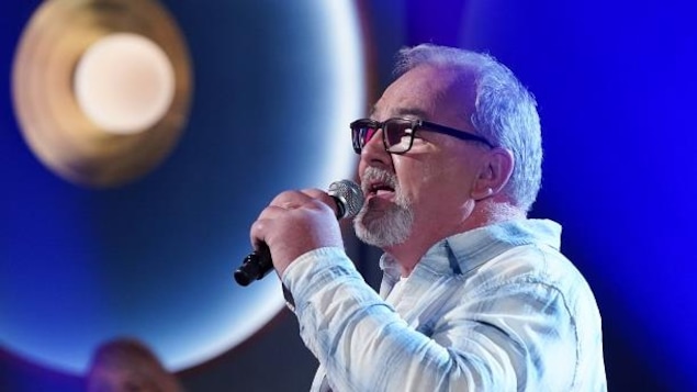 Un homme qui chante, micro à la main. Un homme qui chante, micro à la main.