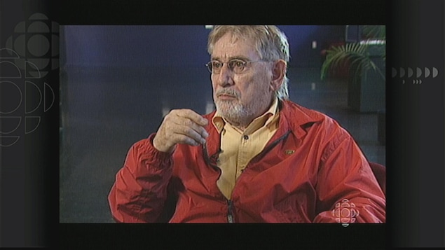 Un homme portant un blouson rouge, assis. Un homme portant un blouson rouge, assis.