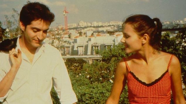 Un jeune couple se tient la main, en surplomb de toits Un jeune couple se tient la main, en surplomb de toits
