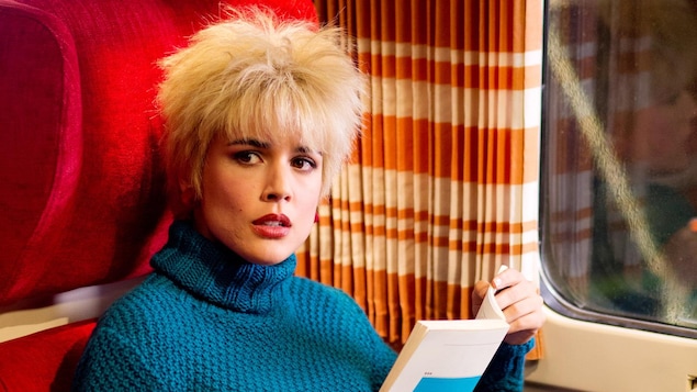 Une jeune femme blonde, assise dans un train, lit un livre. Une jeune femme blonde, assise dans un train, lit un livre.