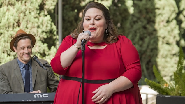 Elle porte une robe rouge. Elle chante, accompagnée d'un claviériste. Elle porte une robe rouge. Elle chante, accompagnée d'un claviériste.