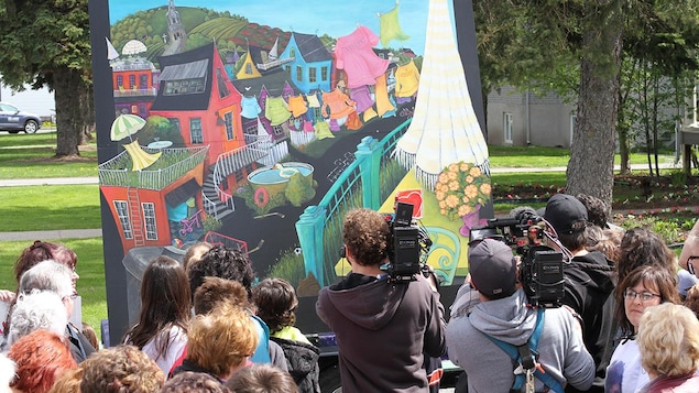 Des caméra filment un grand tableau dans un parc.