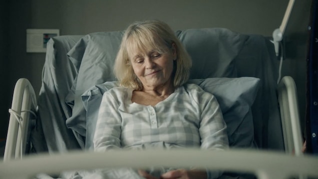 France (Monique Spaziani) est allongée dans son lit d'hôpital.