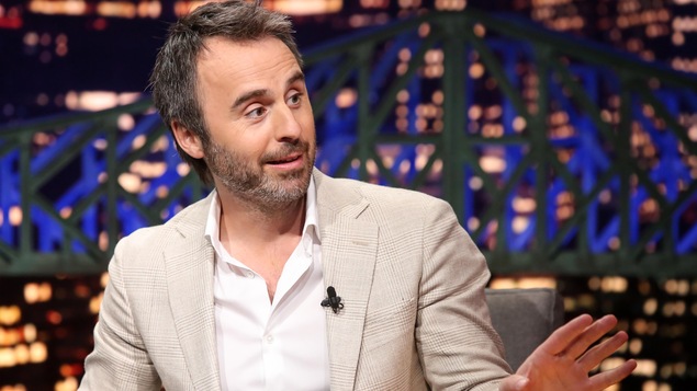 L'humoriste porte une chemise et un veston.