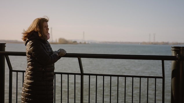 La comédienne Marina Orsini regarde le fleuve au loin sur un pont.