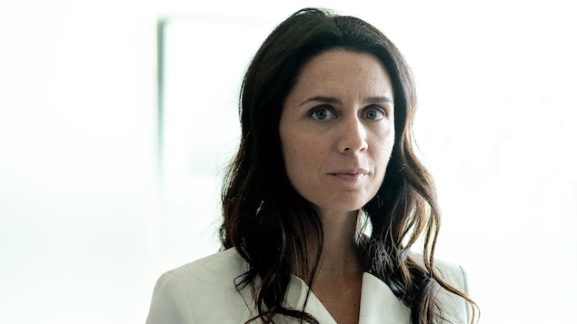Ariane a de longs cheveux bruns.Elle porte une veste blanche et elle est debout. Ariane a de longs cheveux bruns.Elle porte une veste blanche et elle est debout.
