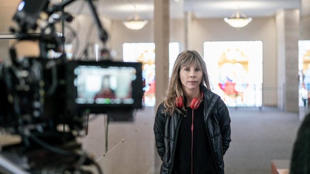 La réalisatrice Louise Archambault, sur son plateau de tournage, avec un casque autour du cou et entourée de caméras. La réalisatrice Louise Archambault, sur son plateau de tournage, avec un casque autour du cou et entourée de caméras.