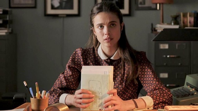 Une jeune femme (Margaret QUalley) assise à un bureau, des lettres entre les mains. Une jeune femme (Margaret QUalley) assise à un bureau, des lettres entre les mains.