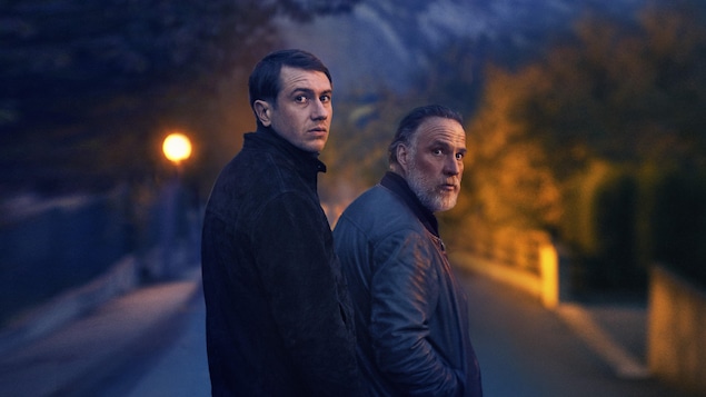Deux hommes (Bastien Bouillon et Bouli Lanners), sur une route, regardent derrière eux. Deux hommes (Bastien Bouillon et Bouli Lanners), sur une route, regardent derrière eux.