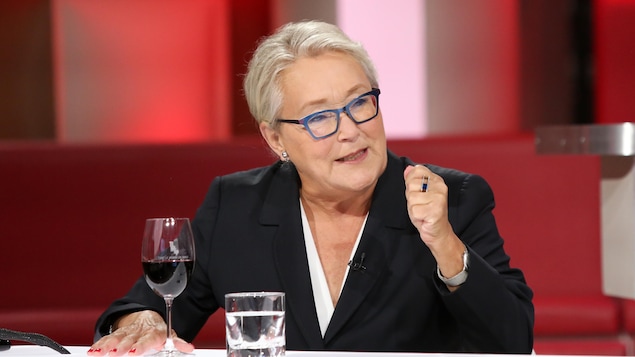 Pauline Marois est à la table des invités. Elle porte un chemisier blanc et un veston foncé. Pauline Marois est à la table des invités. Elle porte un chemisier blanc et un veston foncé.