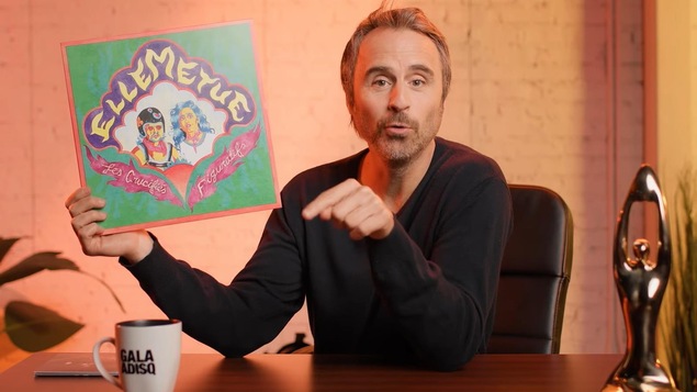 Louis-José Houde tient un disque en vinyle.