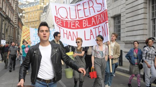 Un jeune homme avec une veste en cuir marche en tête d'une marche de la Fierté. Un jeune homme avec une veste en cuir marche en tête d'une marche de la Fierté.