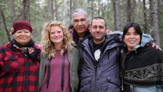 Cinq personnes s'enlacent dans la forêt. Cinq personnes s'enlacent dans la forêt.