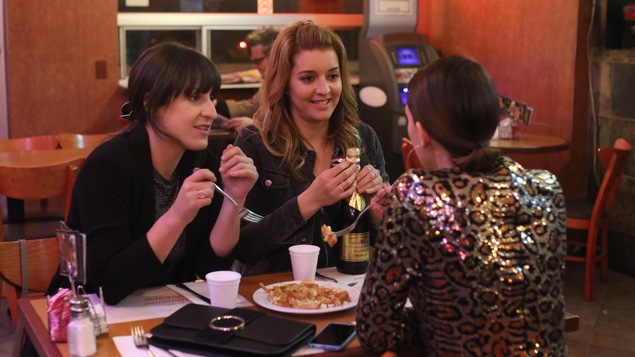 Trois femmes discutent autour d'une poutine au restaurant. Trois femmes discutent autour d'une poutine au restaurant.