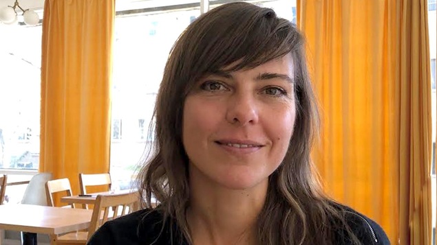 Une femme (Sophie Deraspe) en gros plan, devant des rideaux jaunes. Une femme (Sophie Deraspe) en gros plan, devant des rideaux jaunes.