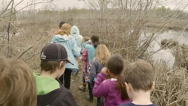 Des enfants qui marchent dans un marais