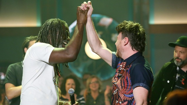 Les deux artistes se serrent la main dans les air. Les deux artistes se serrent la main dans les air.