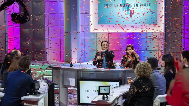 Guy et Diane posent leur main sur leur verre pour empêcher les confettis de tomber dedans. Guy et Diane posent leur main sur leur verre pour empêcher les confettis de tomber dedans.