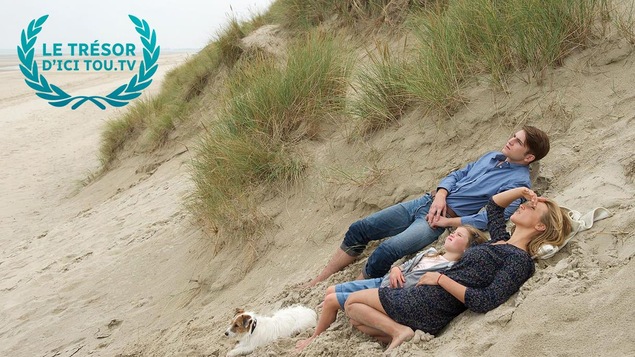 Un homme, une femme et une fillette allongés sur une dune de sable. Un homme, une femme et une fillette allongés sur une dune de sable.