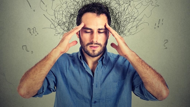 Un homme se tient la tête avec les deux mains. Il y a des illustrations autour de sa fête qui nous aident à comprendre qu'il est stressé.