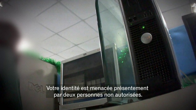 On voit une image floutée d'ordinateurs avec un texte parlant de vol d'identité On voit une image floutée d'ordinateurs avec un texte parlant de vol d'identité